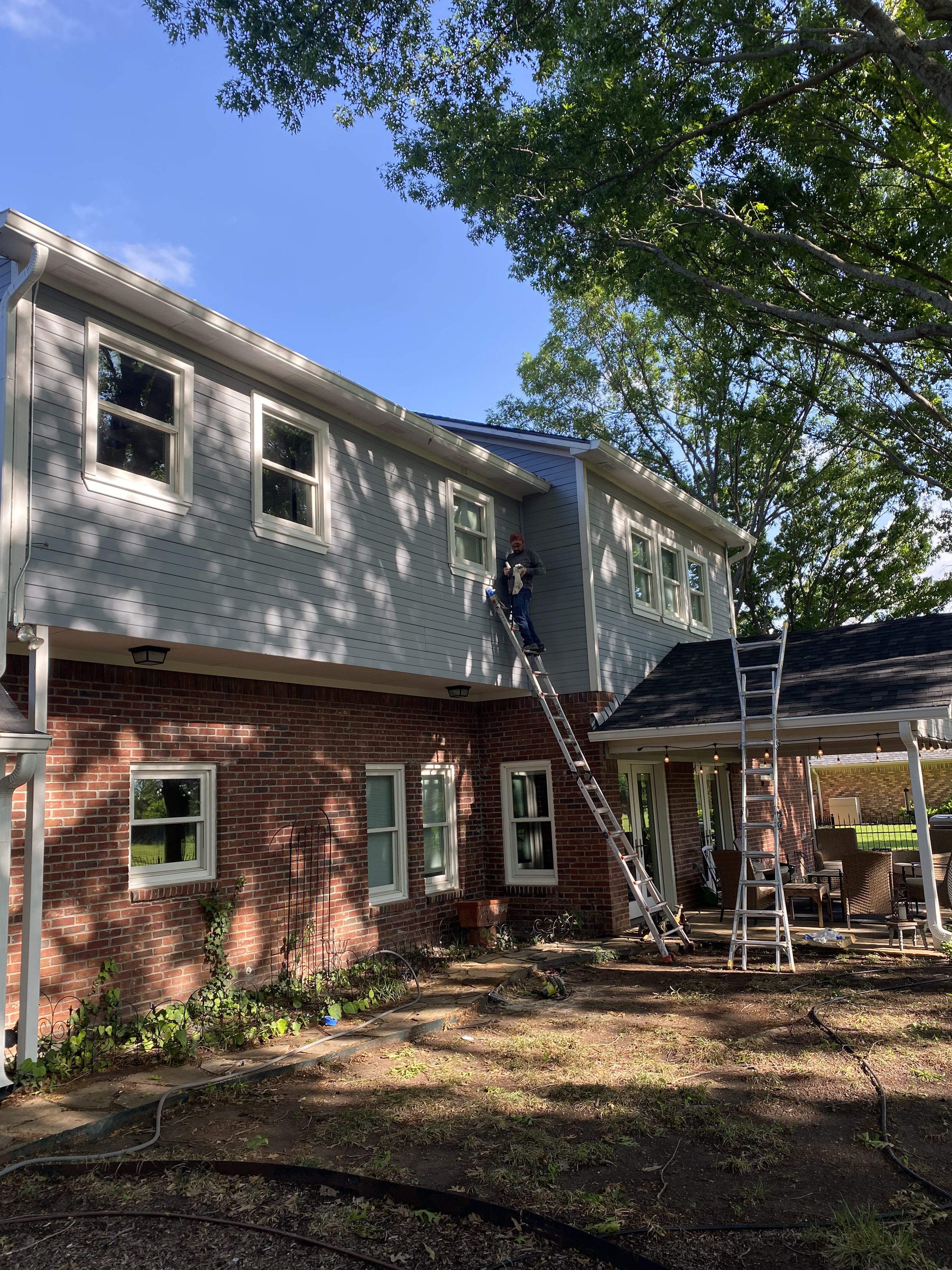 A partially enclosed shower stall made of glass and tiles, featuring a rain shower head, handheld shower head, and wall-mo...